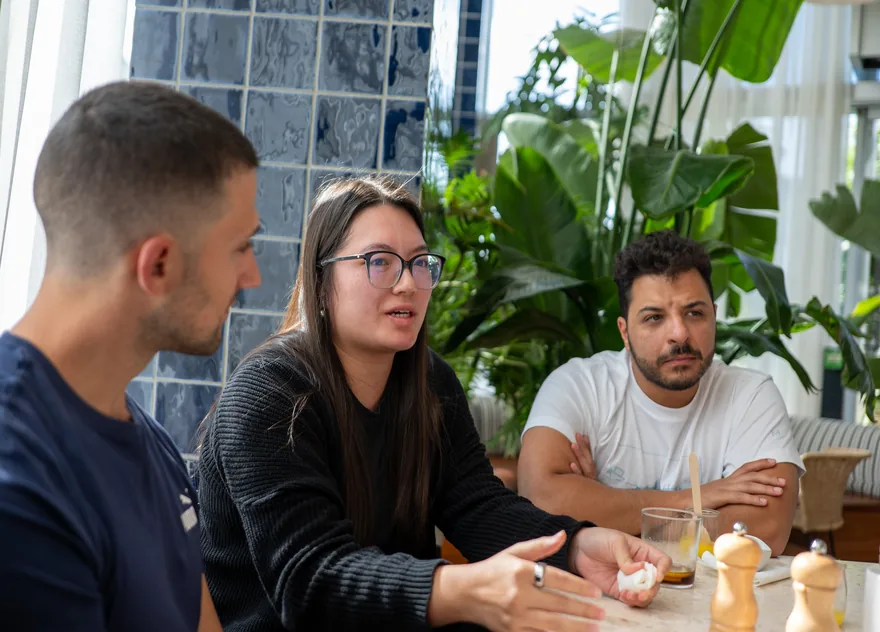 Three people talking a problem through across a table